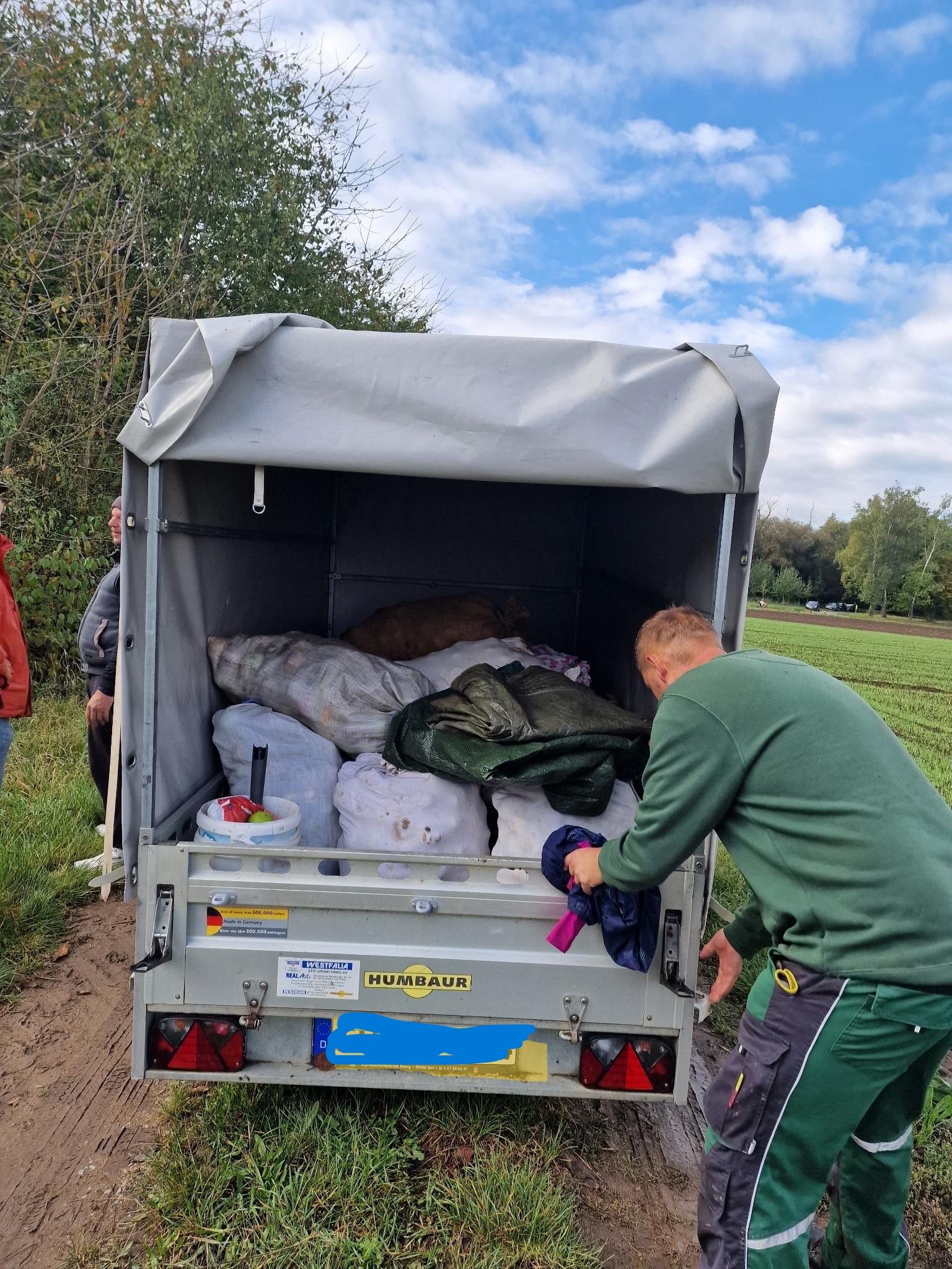 Apfelernte im Transporter In einem Autoanhänger stehen Säcke mit Äpfel. Die Klappe wird gerade geschlossen