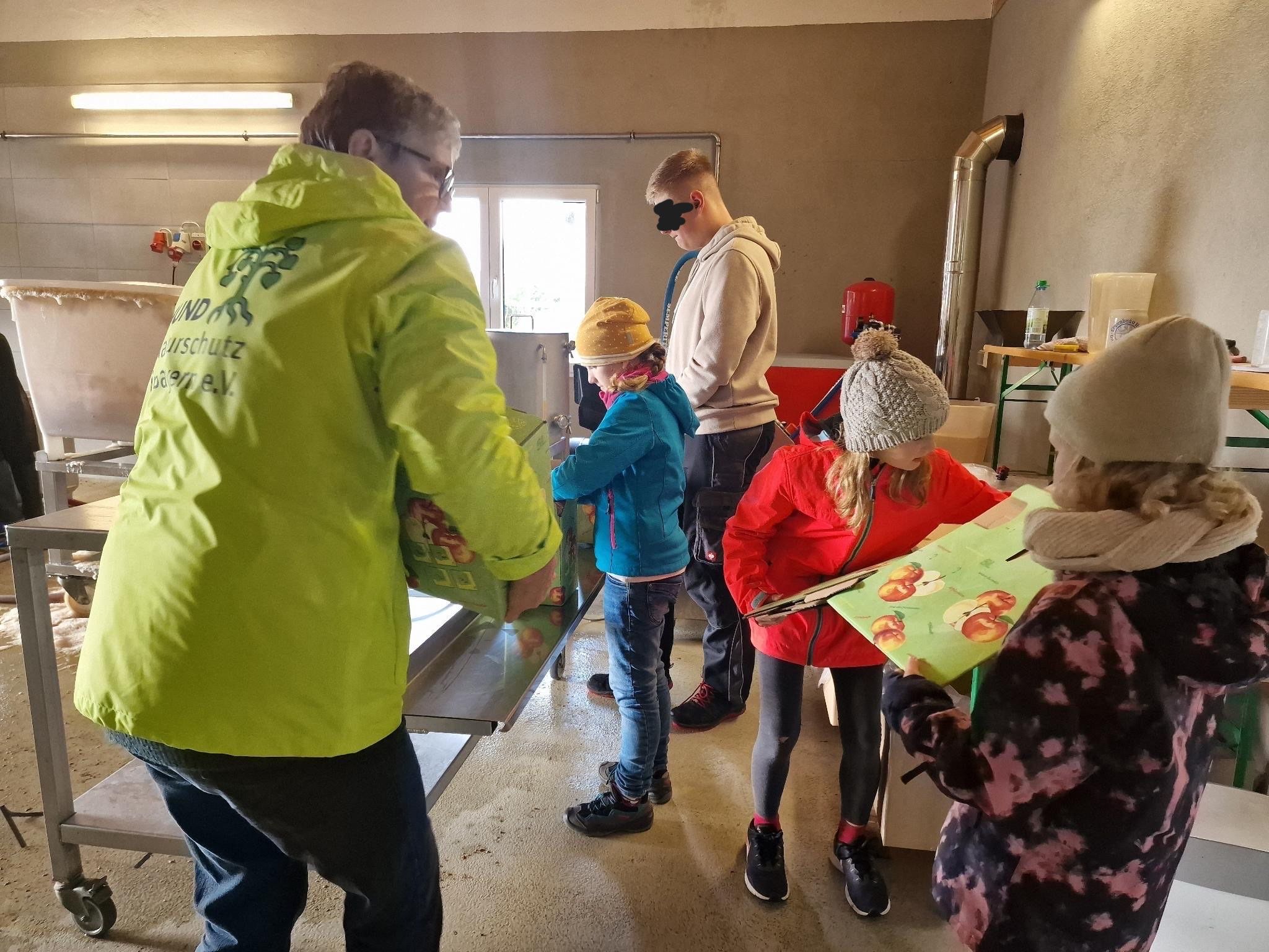 Apfelernte Abfüllung Mehrere Personen falten die Umpackung für Apfelsaft auseinander